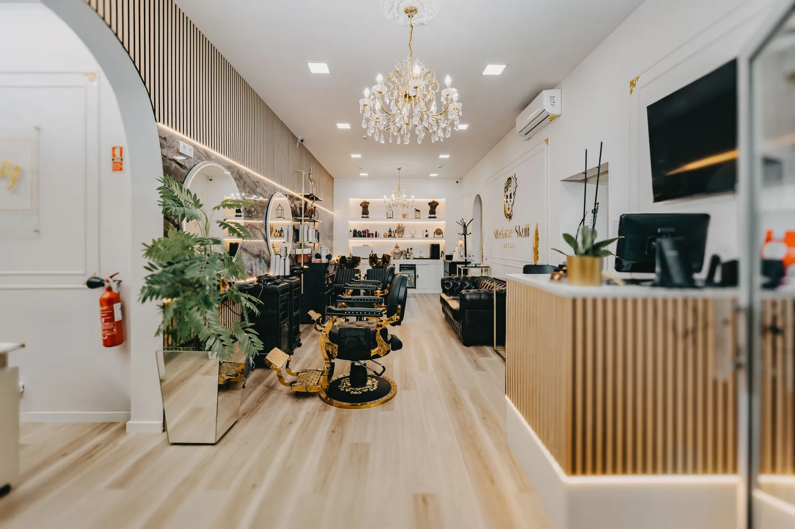 Interior luminoso da Madame Skull Beauty com cadeiras douradas e receção